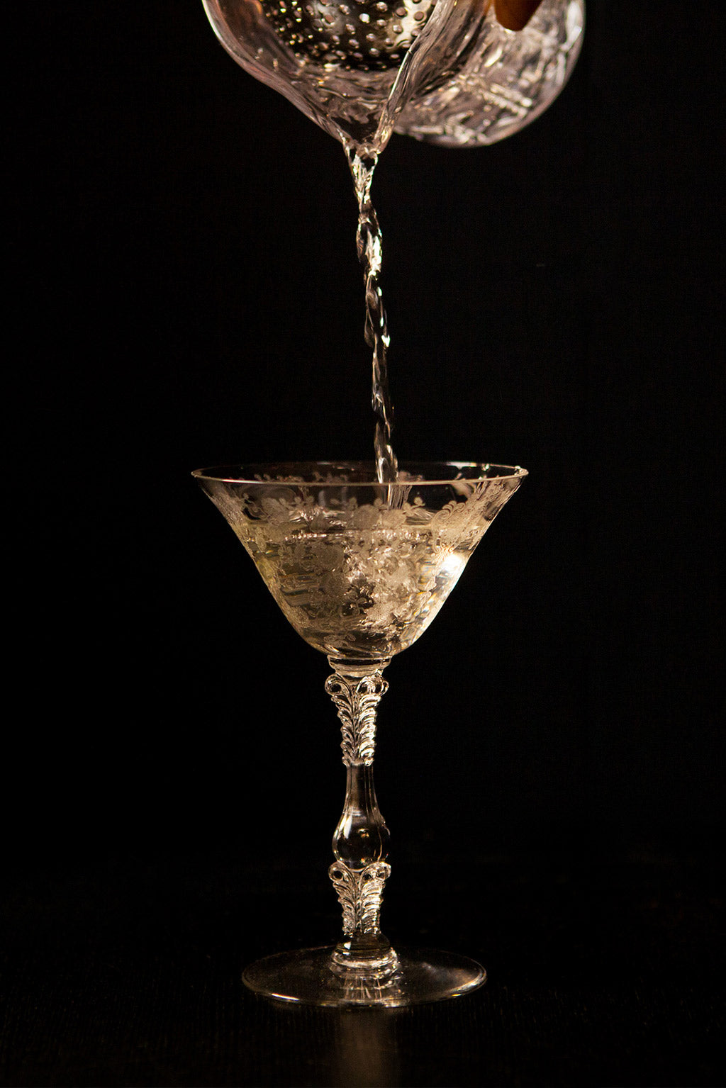 A martini cocktail being poured into a glass